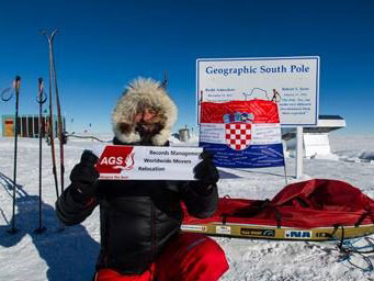 Man holding en AGS banner in Alaska with a Croatian flag at the back